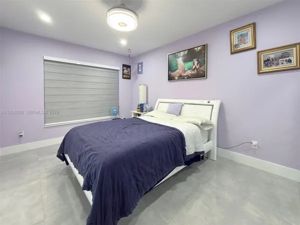 a bedroom with a bed and painting on the wall