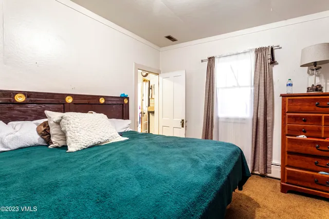 a bed sitting in a bedroom next to a window