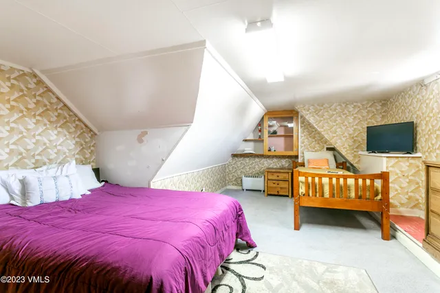 a bed sitting in a bedroom next to a couch