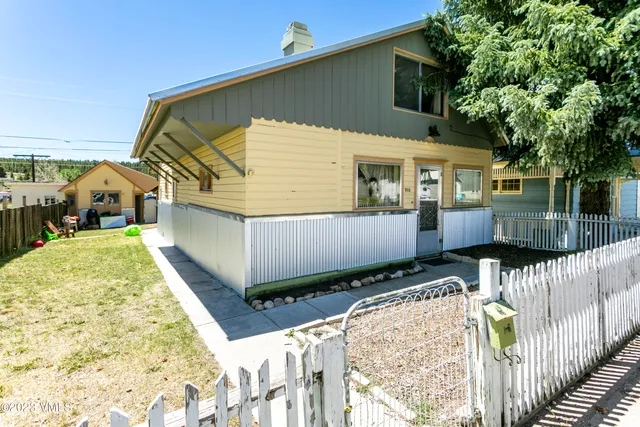 a view of a house with a wooden fence