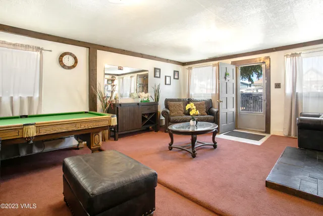 a living room with furniture a rug and a large window