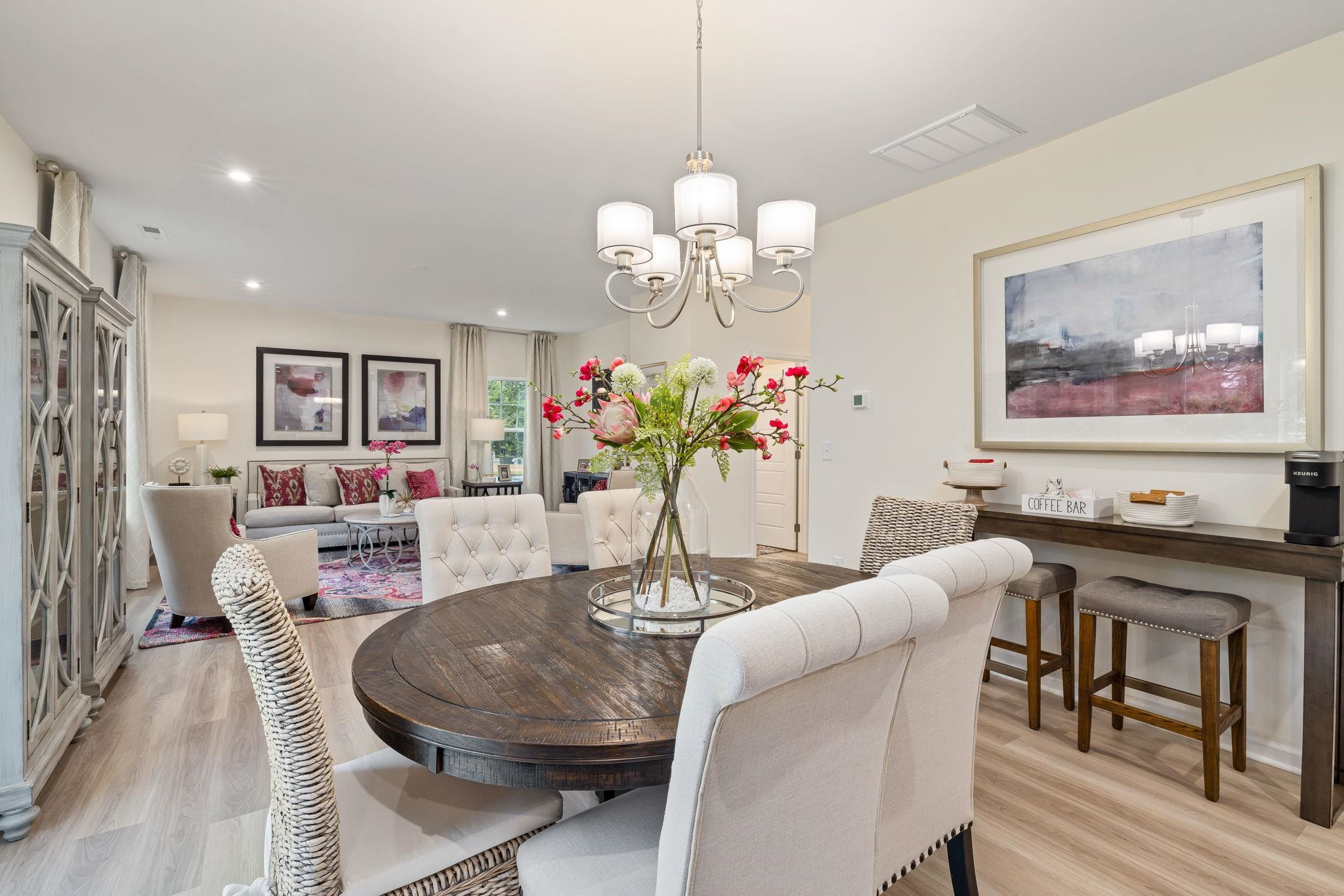 6512 Winter Spring Drive Wake Forest, NC 27587 - Photo 6 of 34 a dining room with wooden floor a chandelier a wooden table and chairs