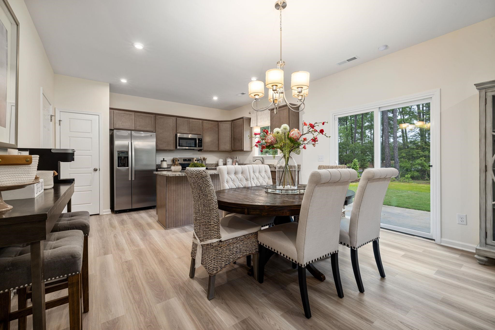6512 Winter Spring Drive Wake Forest, NC 27587 - Photo 7 of 34 a view of a dining room with furniture a chandelier and wooden floor