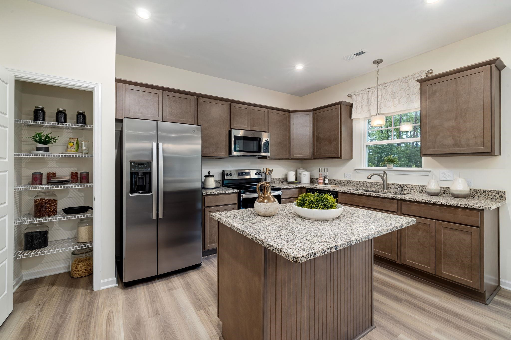 6512 Winter Spring Drive Wake Forest, NC 27587 - Photo 8 of 34 a kitchen with granite countertop stainless steel appliances a refrigerator a sink a stove a refrigerator cabinets and wooden floor