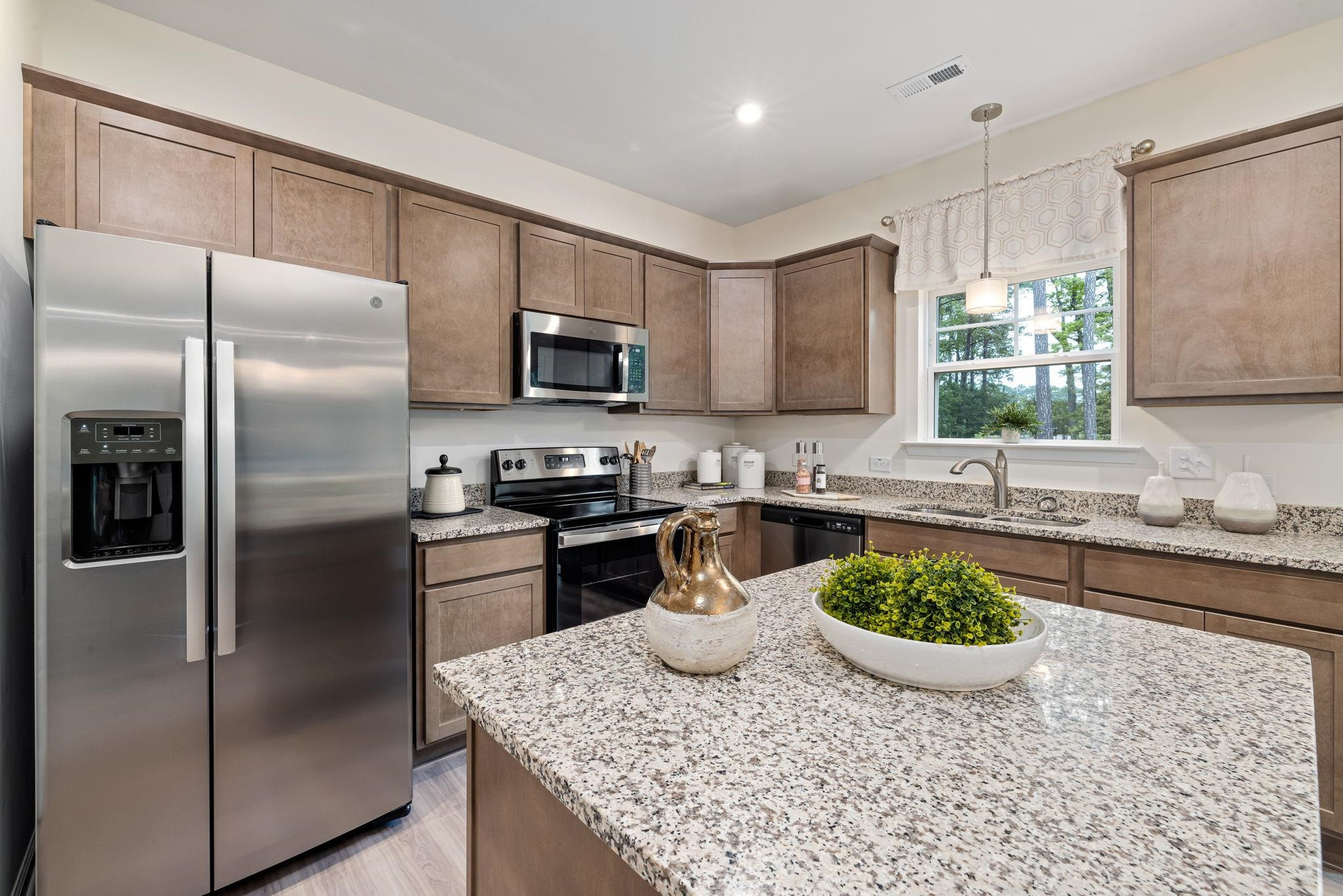 6512 Winter Spring Drive Wake Forest, NC 27587 - Photo 9 of 34 a kitchen with a stove a sink and a refrigerator