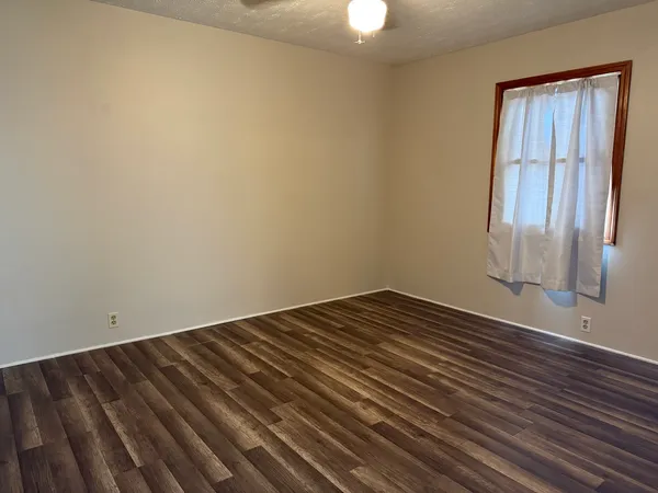 a view of a room with wooden floor and fan