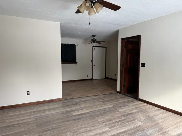 a view of a livingroom with a ceiling fan and wooden floor