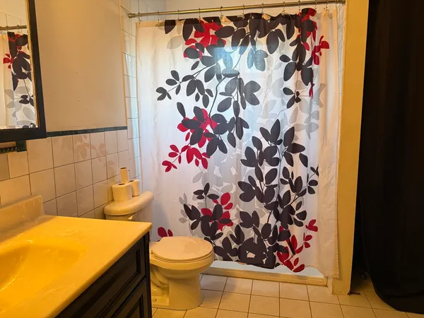 a bathroom with a toilet and a shower curtain