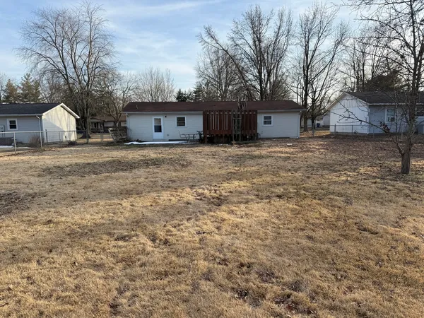 a view of a house with a yard and large tree