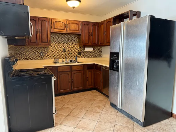 a kitchen with stainless steel appliances granite countertop a refrigerator and a sink