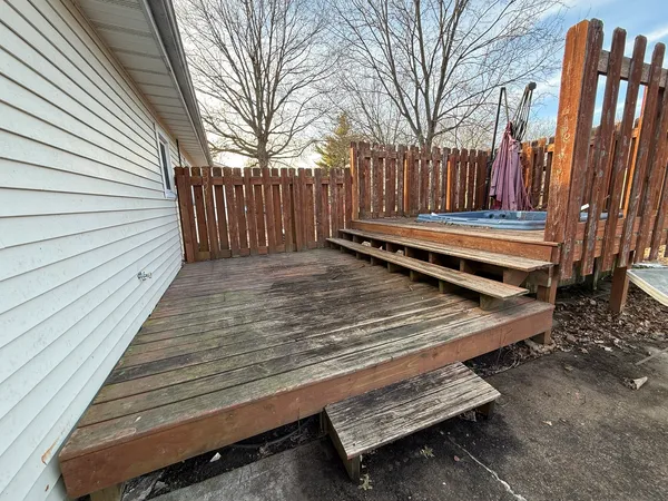 a view of a backyard with table and chairs with wooden fence