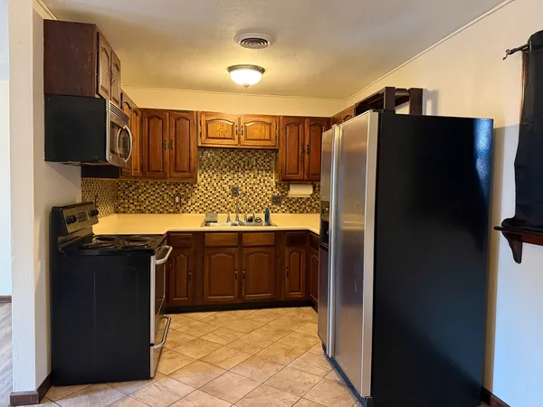 a kitchen with stainless steel appliances granite countertop a refrigerator and a sink