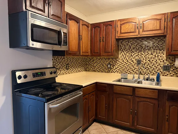a kitchen with granite countertop cabinets stainless steel appliances and wooden cabinets