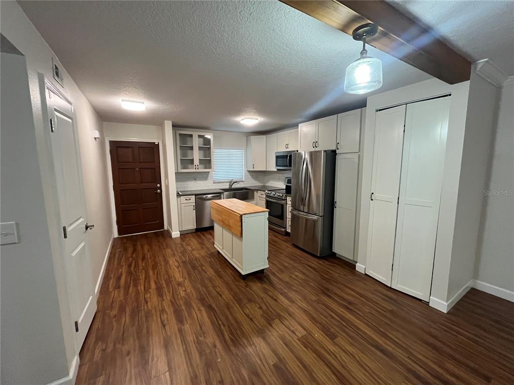 210 Magnolia Road, Unit 104 Maitland, FL 32751 - Photo 3 of 16 a kitchen with stainless steel appliances a refrigerator and wooden floor