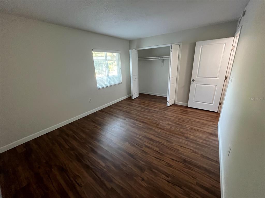 210 Magnolia Road, Unit 104 Maitland, FL 32751 - Photo 8 of 16 an empty room with wooden floor and windows