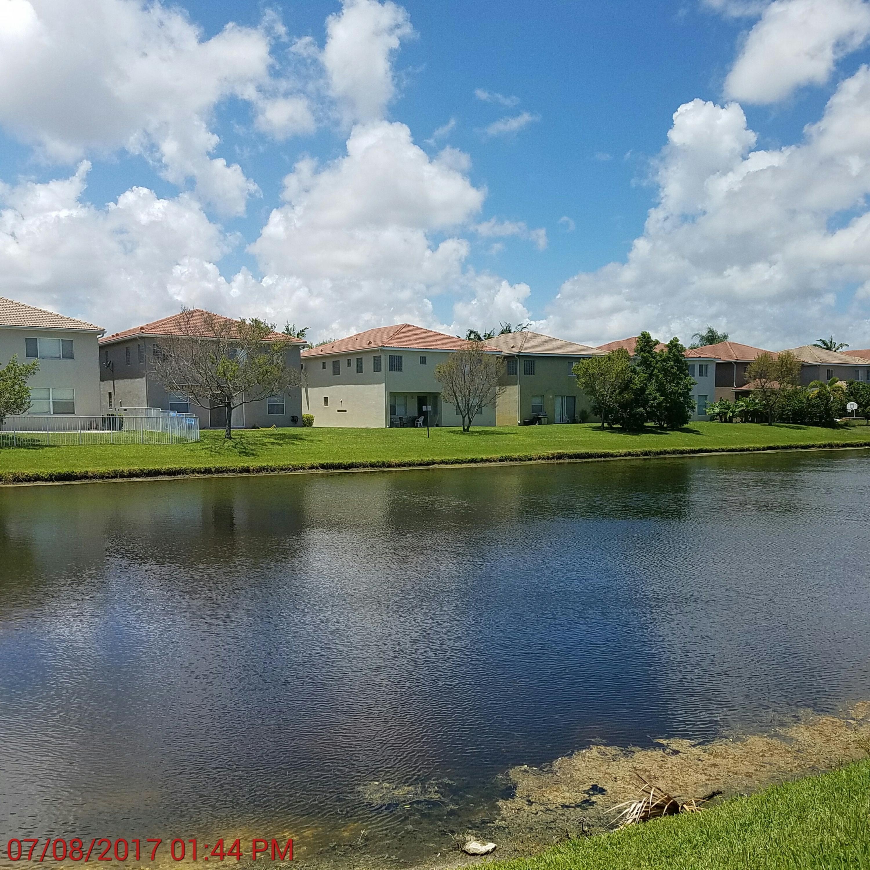 3117 Laurel Ridge Circle Riviera Beach, FL 33404 - Photo 18 of 27 a view of a lake with a big yard