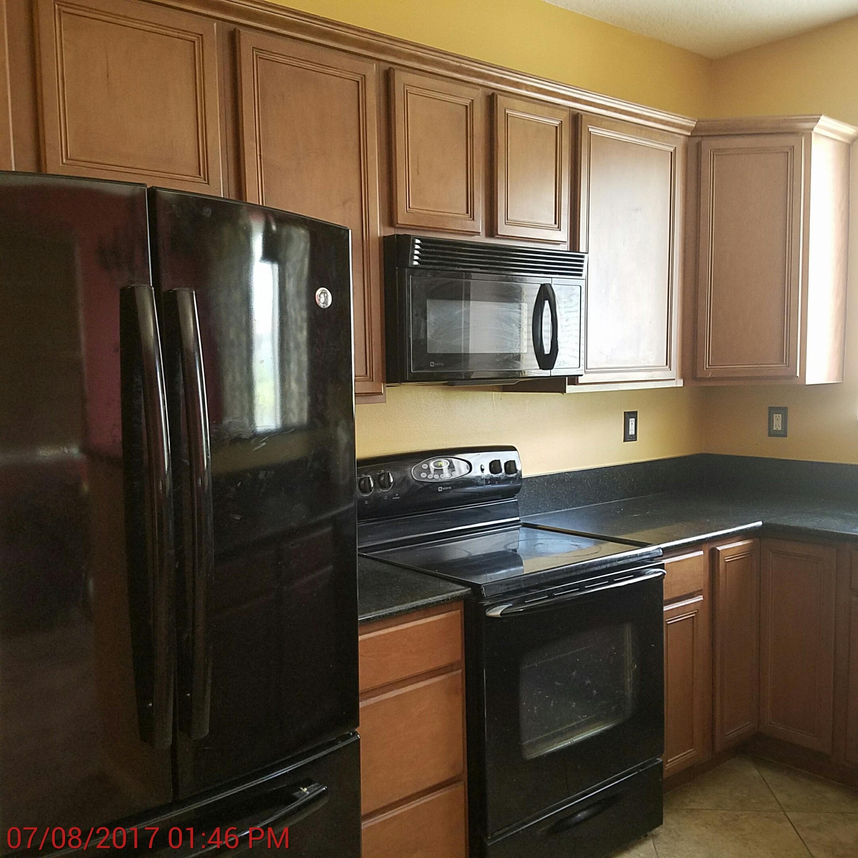 3117 Laurel Ridge Circle Riviera Beach, FL 33404 - Photo 2 of 27 a kitchen with granite countertop a stove and a refrigerator