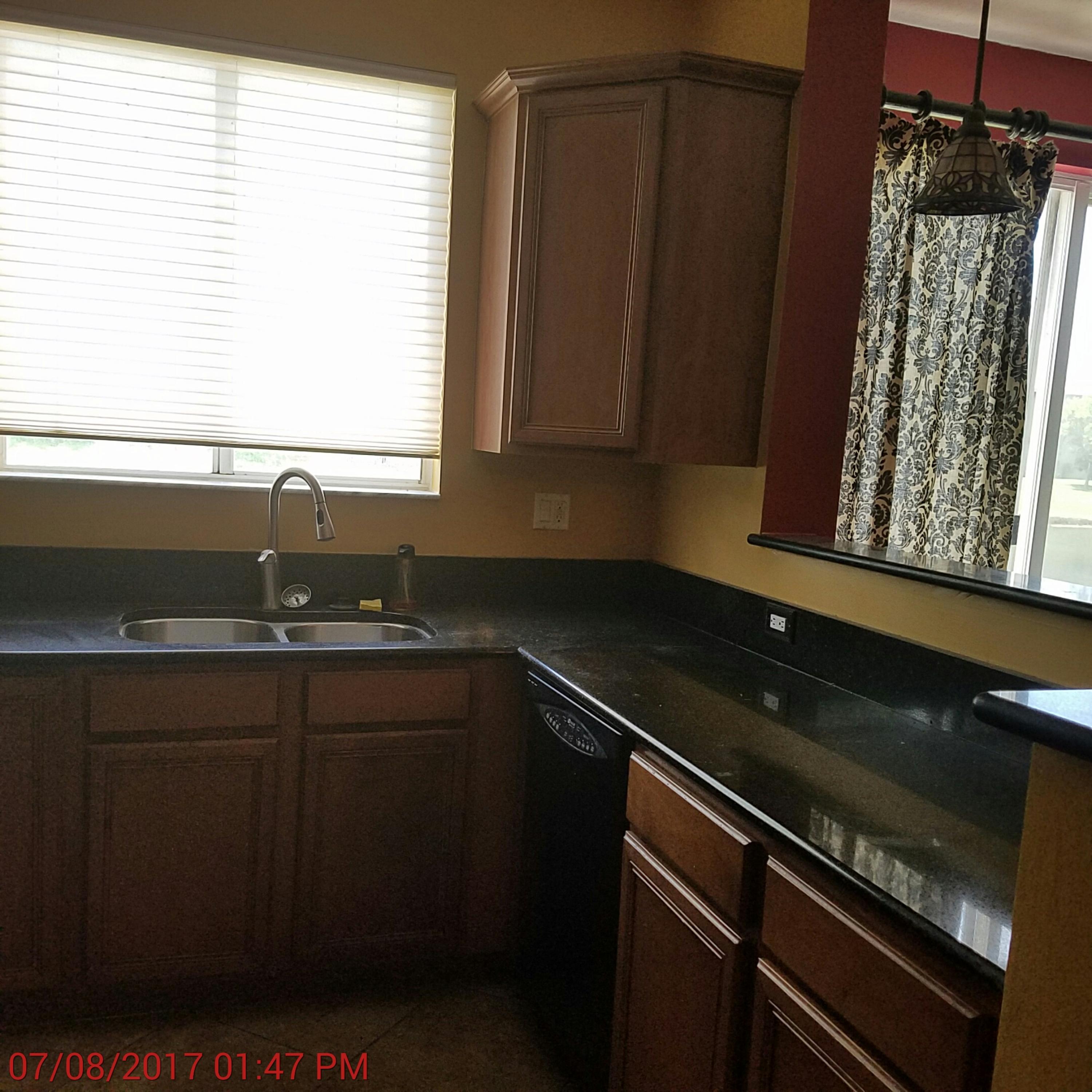 3117 Laurel Ridge Circle Riviera Beach, FL 33404 - Photo 3 of 27 a kitchen with a sink a stove and a window