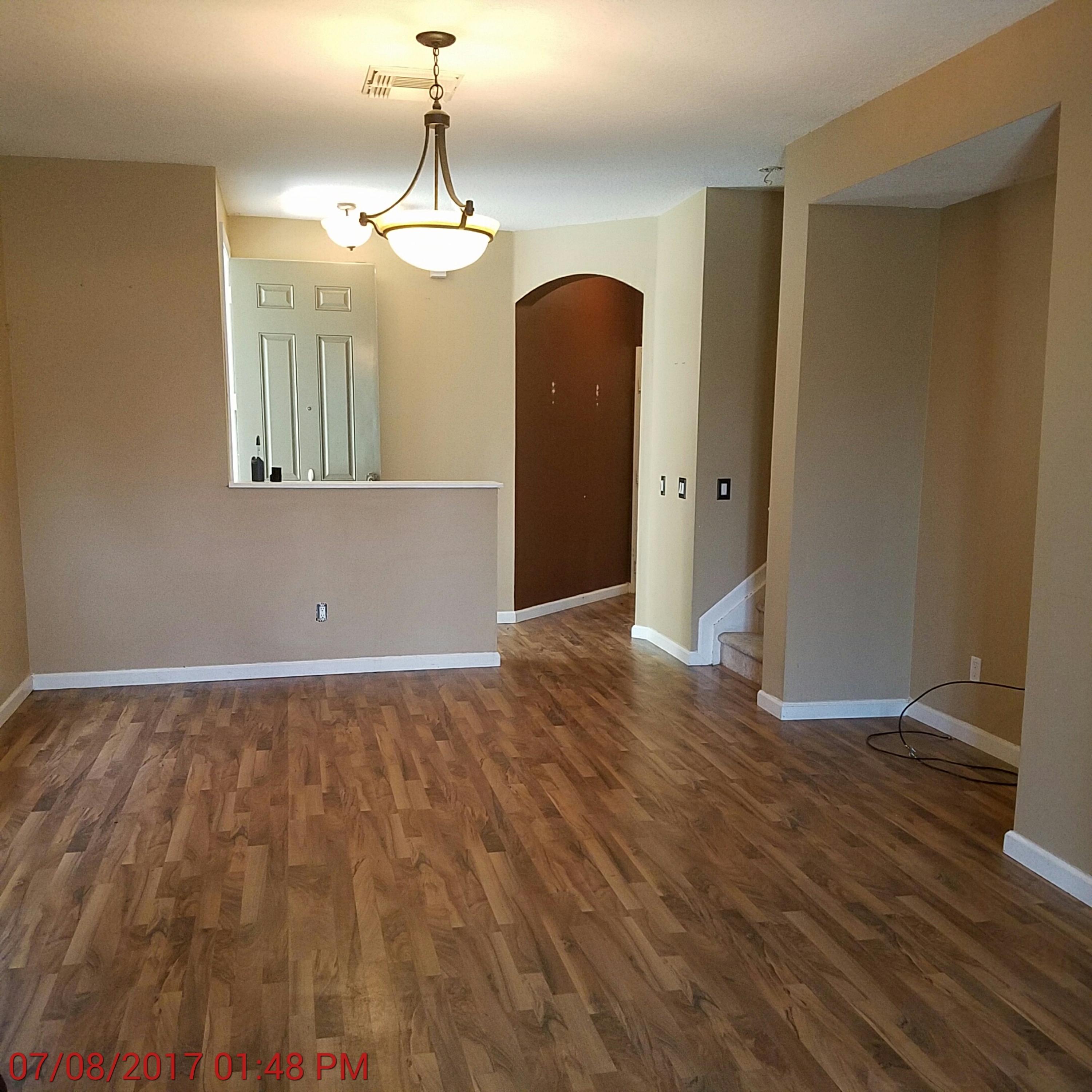 3117 Laurel Ridge Circle Riviera Beach, FL 33404 - Photo 8 of 27 a view of a room with wooden floor and chandelier