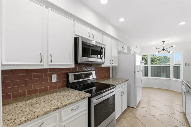 a kitchen with stainless steel appliances granite countertop a sink and a stove