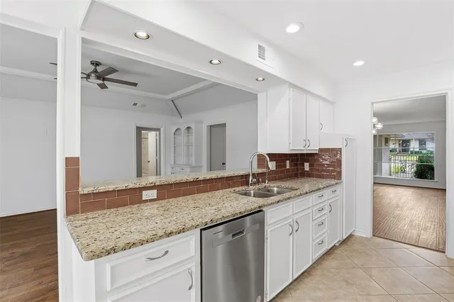 a bathroom with a granite countertop double vanity sink and mirror