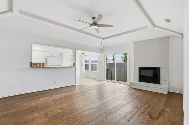 a view of a livingroom with wooden floor and a ceiling fan
