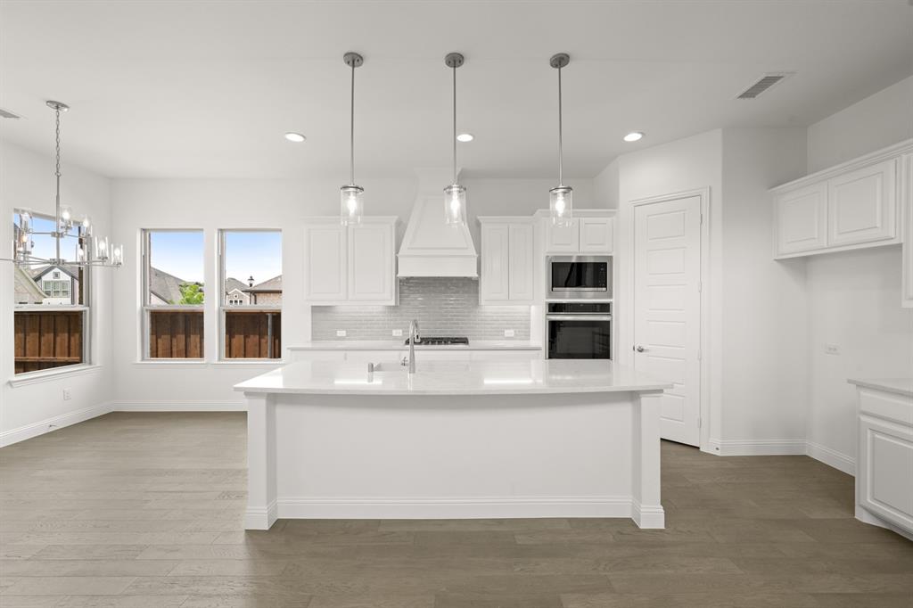 1536 Euclid Alley Corinth, TX 76208 - Photo 14 of 35 a large kitchen with kitchen island a large counter top space a sink and appliances