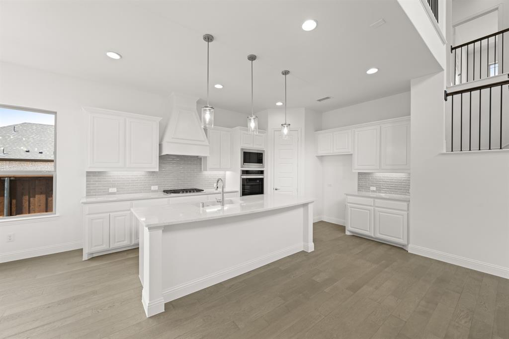 1536 Euclid Alley Corinth, TX 76208 - Photo 15 of 35 a large white kitchen with stainless steel appliances kitchen island granite countertop a sink and cabinets