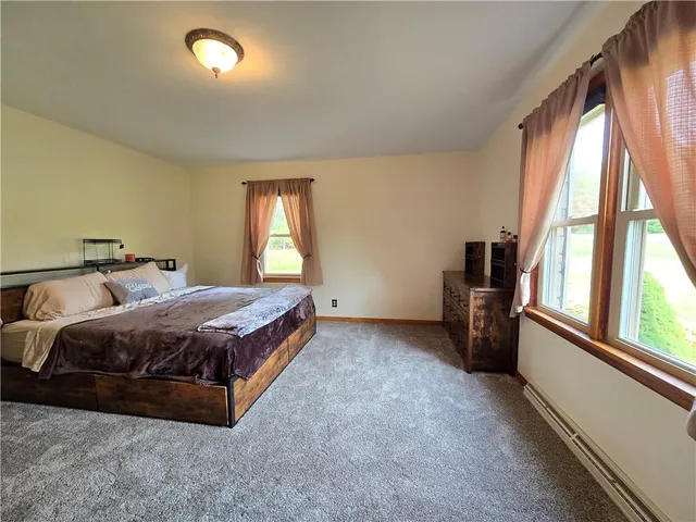 a spacious bedroom with a bed and a large window
