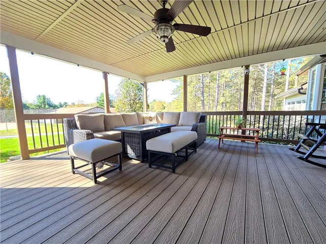 a balcony with wooden floor table and chairs