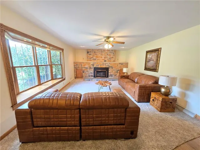 a bedroom with a bed couch chandelier and a window