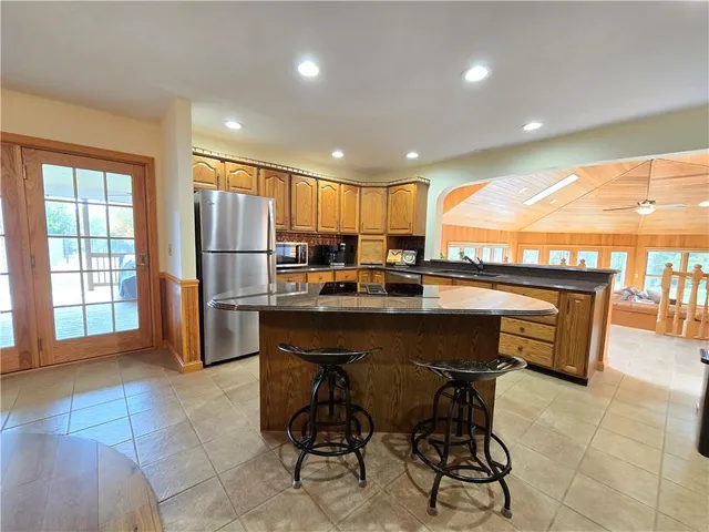 a kitchen with a sink a refrigerator and wooden cabinets