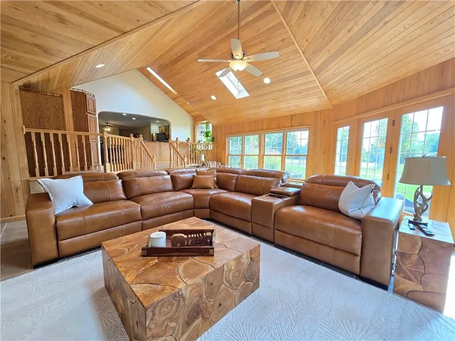 a living room with furniture a large window and a chandelier
