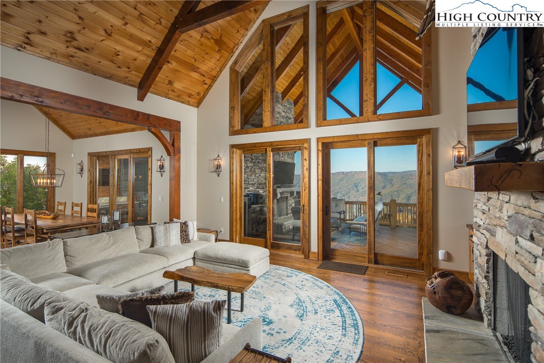 331 Goldenrod Road Boone, NC 28607 - Photo 3 of 50 a living room with furniture a fireplace and a floor to ceiling window