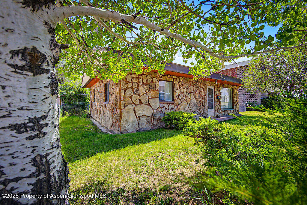 625 Russell Street Craig, CO 81625 - Photo 4 of 35 a view of a house with a small yard and a large tree