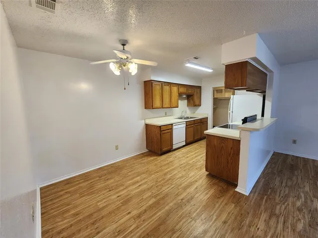 a kitchen with wooden floors and stainless steel appliances