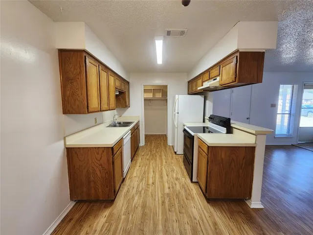 a kitchen with stainless steel appliances granite countertop wooden floors a sink and a stove
