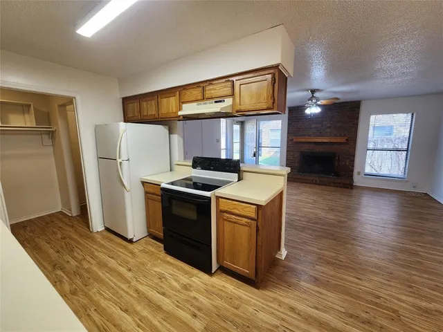 a kitchen with stainless steel appliances granite countertop a refrigerator a stove and a wooden floors