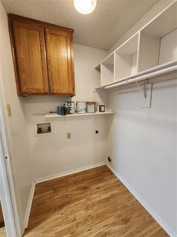 a view of a kitchen with wooden floor and cabinets