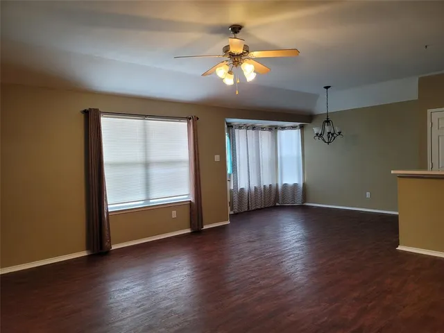 a view of a livingroom with wooden floor and a ceiling fan