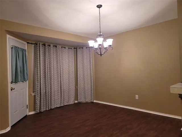 a view of a livingroom with a furniture wooden floor and chandelier