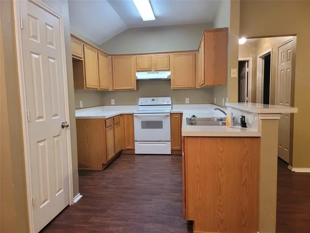 a kitchen with a sink cabinets and wooden floor