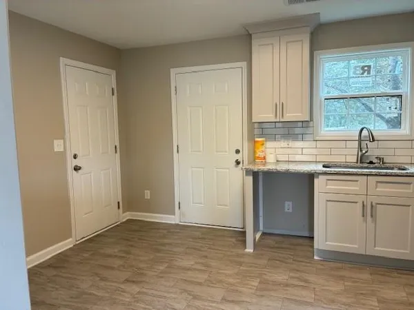 a kitchen with a sink cabinets and wooden floor