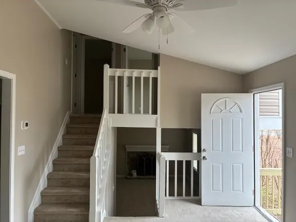 a view of an entryway with wooden floor cabinet and a living room