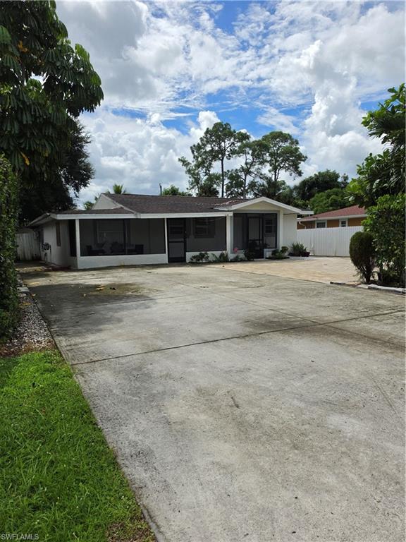 5230 Warren Street Naples, FL 34113 - Photo 1 of 22 Single-story residence featuring a screened porch, white exterior, and a large concrete driveway
