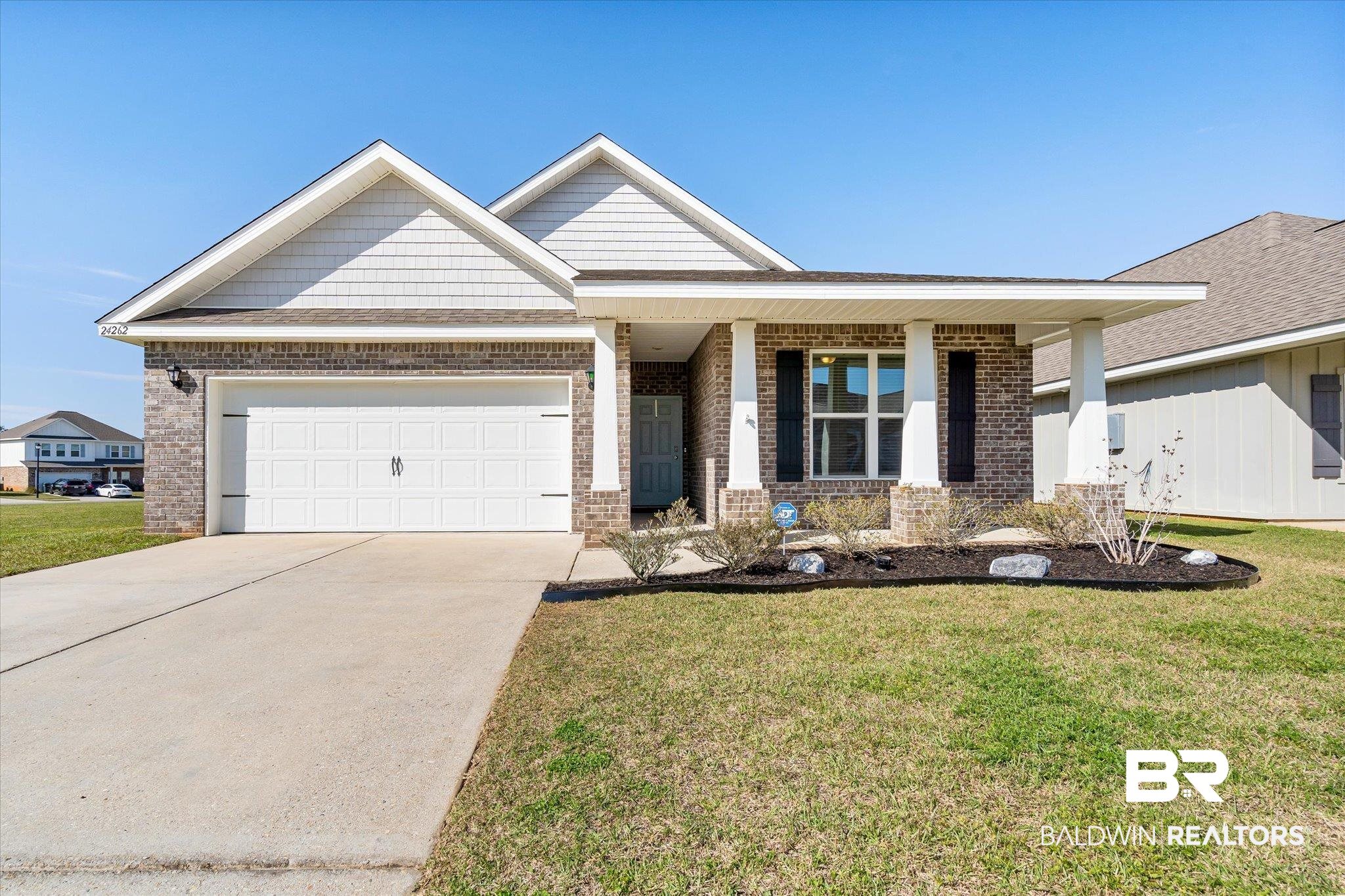 24262 Alydar Loop Daphne, AL 36526 - Photo 1 of 33 View of front facade featuring driveway, brick siding, a front lawn, and an attached garage