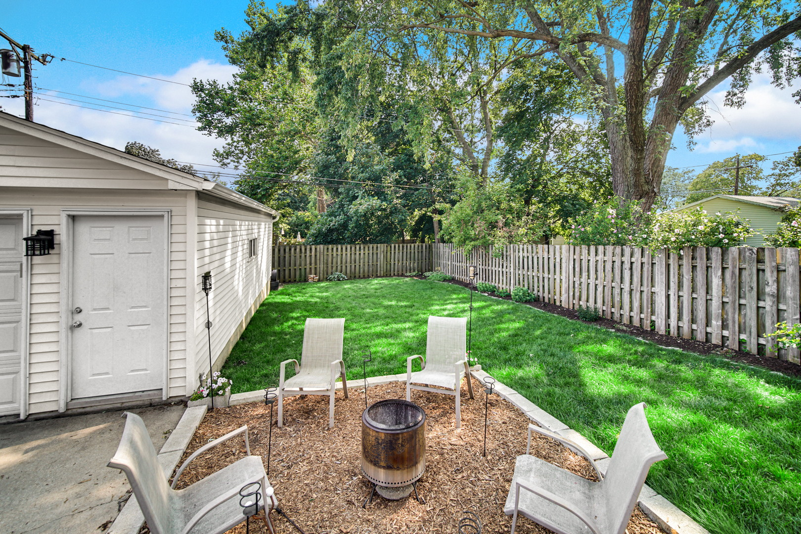 1308 Manchester Road Wheaton, IL 60187 - Photo 24 of 30 a view of a backyard with table and chairs and a fire pit
