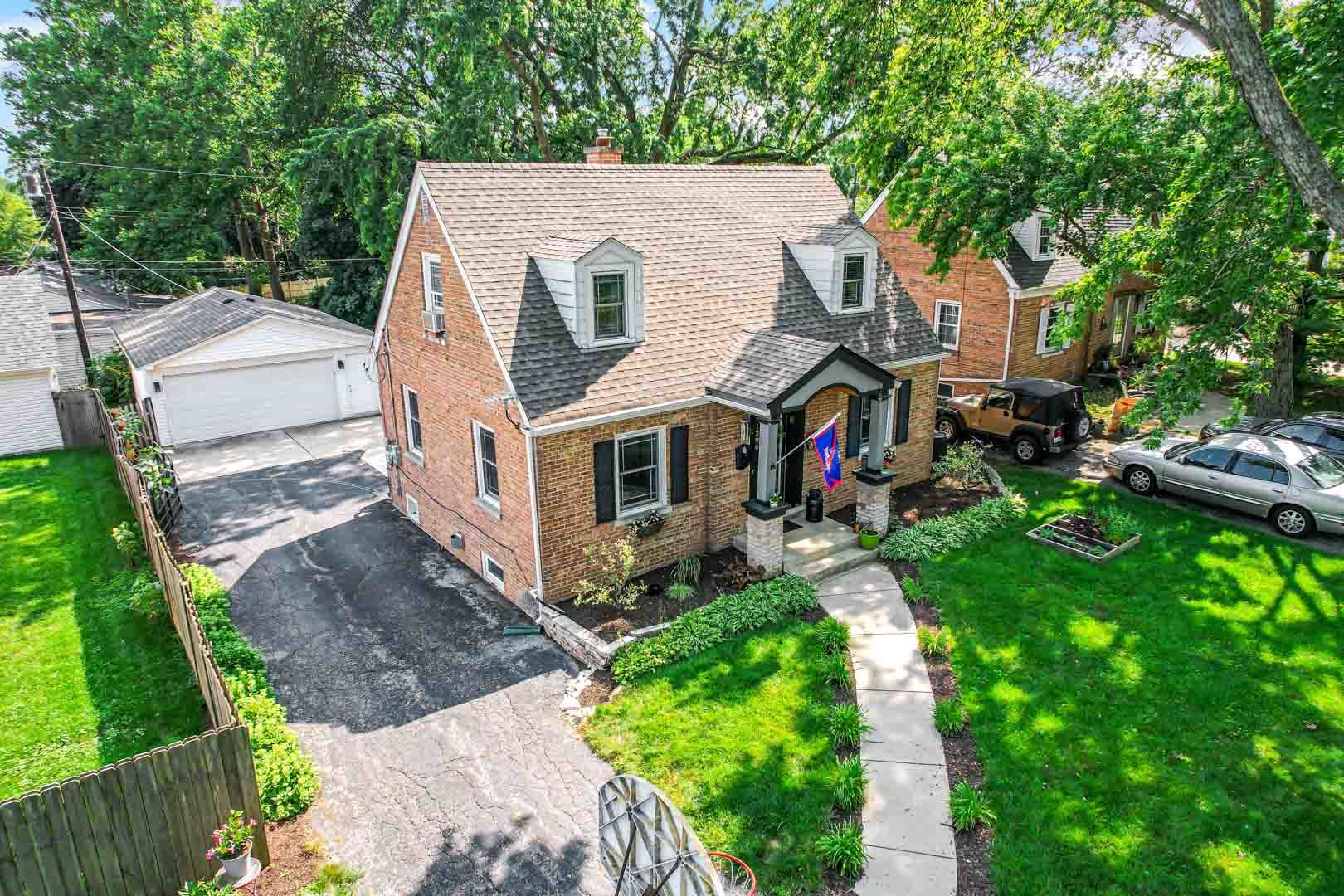1308 Manchester Road Wheaton, IL 60187 - Photo 3 of 30 a view of a white house with a small yard and large trees