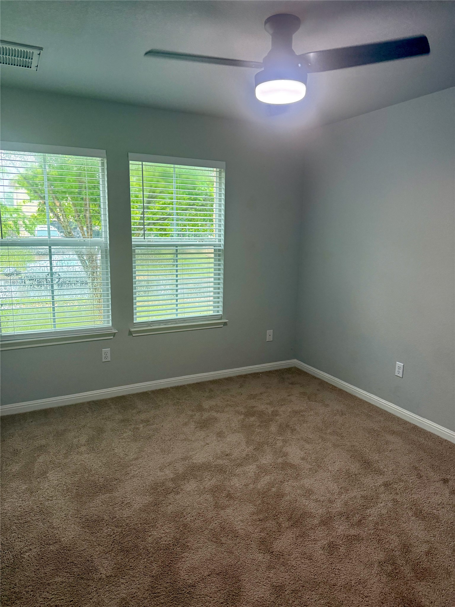 315 Nottingham Loop Kyle, TX 78640 - Photo 11 of 16 Well-lit room with ample natural light, featuring practical carpet flooring and a modern ceiling fan.