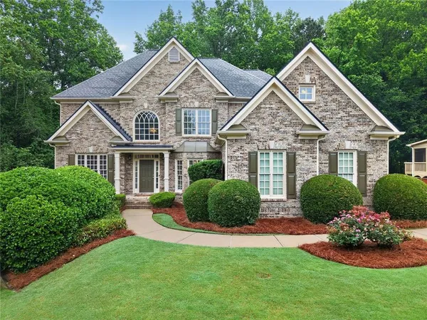 a front view of a house with a yard and green space